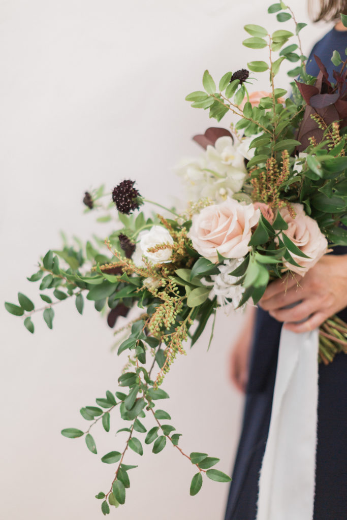 bride holds bouquet in post about using Asana for wedding planners