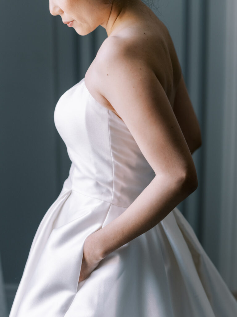 A woman in a white dress stands elegantly in one of the top Boston wedding venues.