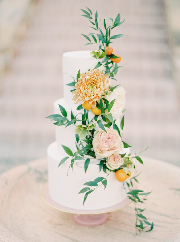 A white wedding cake adorned with beautiful flowers on top at one of boston's top wedding venues.