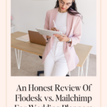 A woman in a pink blazer and white pants stands in an office, writing on a notepad. The text below reads, "An Honest Review Of Flodesk vs. Mailchimp For Wedding Planners – Discover the ultimate email marketing solution tailored for your business needs.
