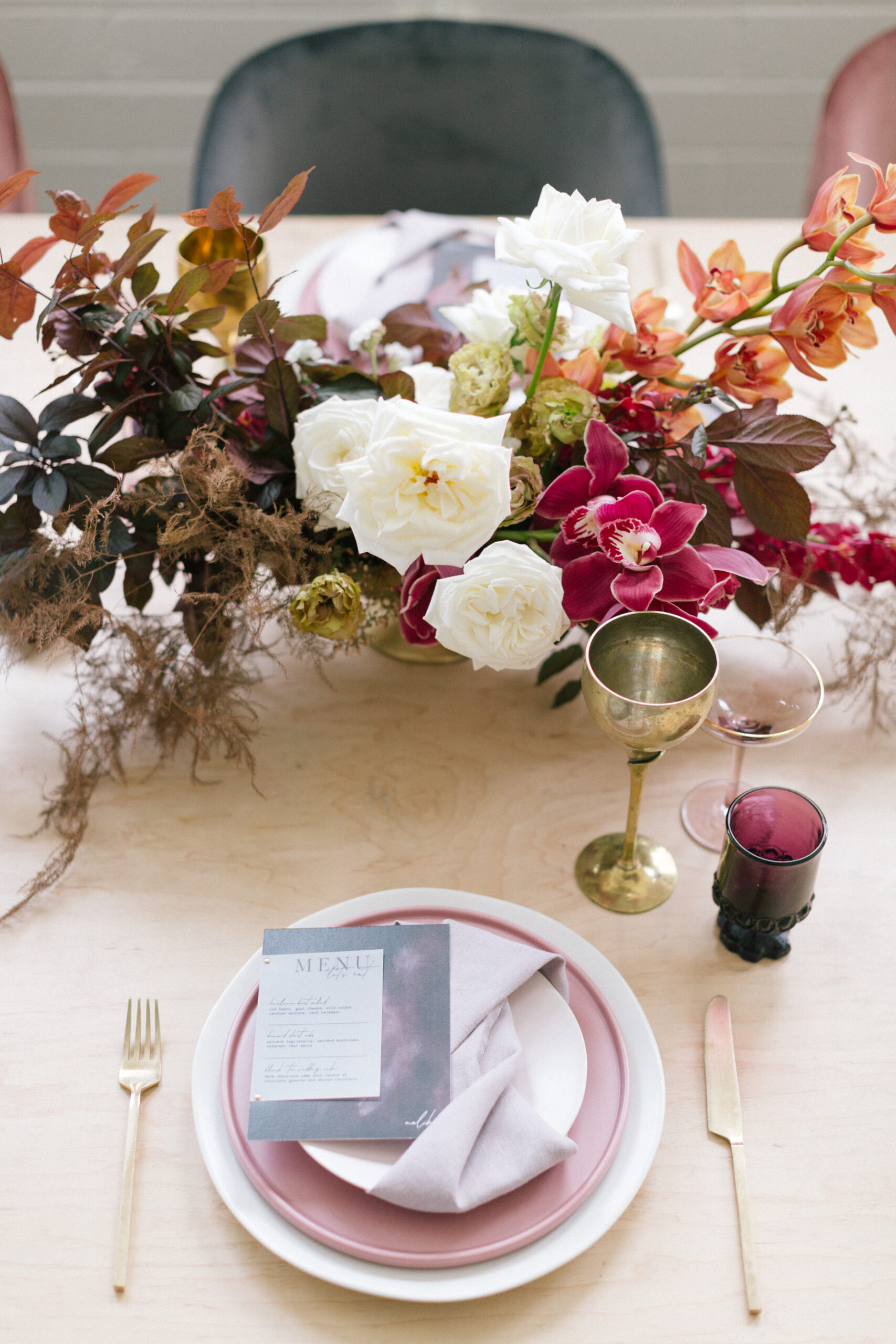 A table adorned with elegant flowers, accompanied by a charming display of a plate and glasses.