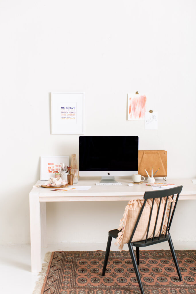 A white desk with a chair and a rug, perfect for creating a cozy workspace during engagement season.
