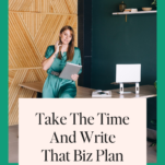 Woman in a green dress stands at a desk holding a tablet, with the text "Write a Business Plan in 2024" displayed below. Modern office decor with wooden and green accents in the background.